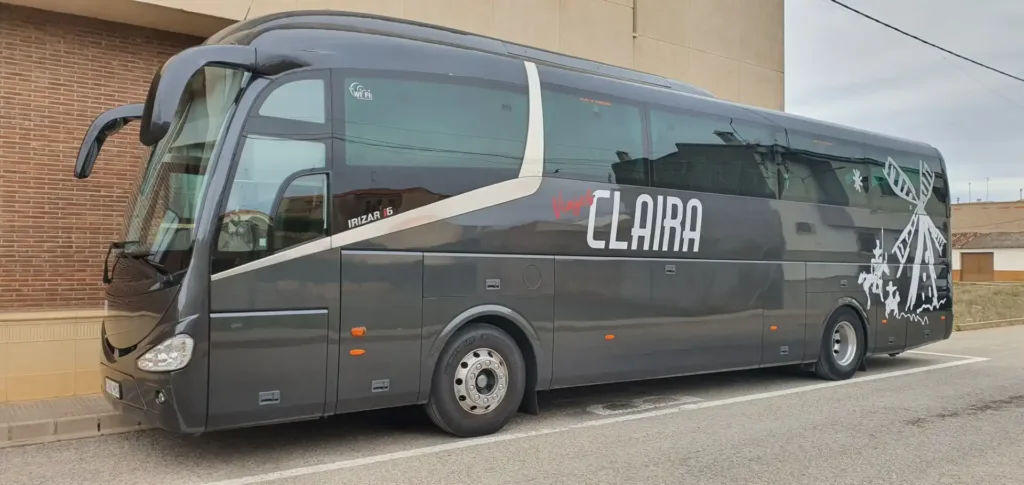 Autobús negro de Viajes Claira modelo Irizar i6, con diseño de Don Quijote y molino, ideal para rutas culturales y excursiones en grupo por La Mancha.