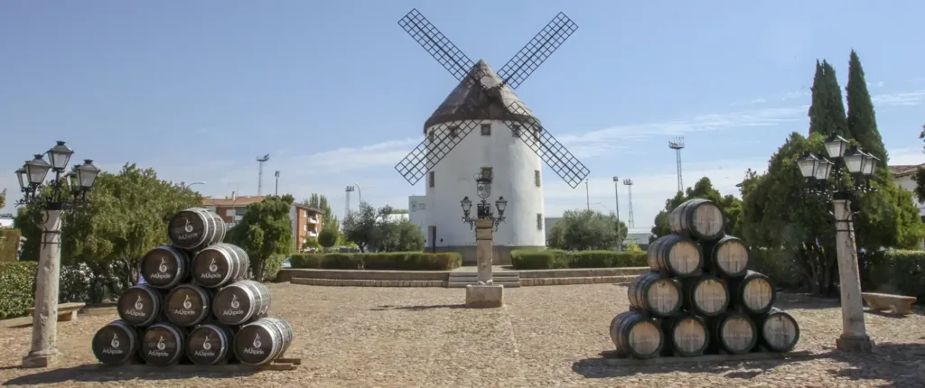 Molino de viento y barricas de vino en Valdepeñas, símbolo del patrimonio manchego y la tradición vinícola, incluido en las excursiones temáticas de Viajes Claira.