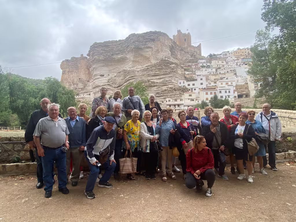 Grupo de mayores ante un castillo manchego durante una excursión para jubilados