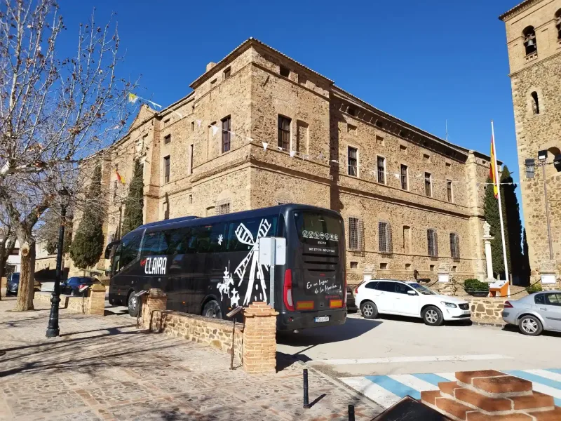 Autobús de Viajes Claira frente al Palacio del Marqués de Santa Cruz en Viso del Marqués, durante una excursión organizada por Castilla-La Mancha para grupos turísticos.